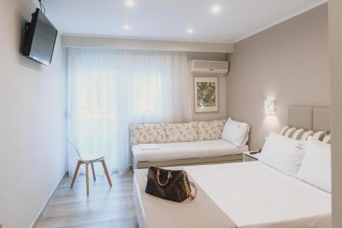 a living room with two beds and a couch at Ammos Beach Seaside Luxury Suites Hotel in Olympic Beach