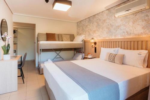 a bedroom with a bed and a desk and bunk beds at Aqua Beachfront Elegant Hotel in Olympic Beach