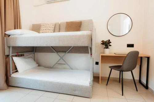 a room with two bunk beds and a desk at Aqua Beachfront Elegant Hotel in Olympic Beach