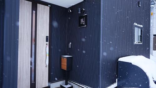 a building with snow falling on the wall at Cloud House Sapporo in Sapporo