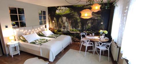 a bedroom with a bed and a table with chairs at Apartamenty dla par Stara Szkoła in Weremowice