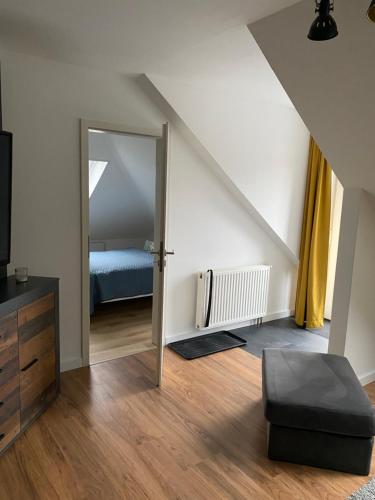 an attic room with a door leading to a bedroom at Ferienwohnung Frers in Rallenbüschen