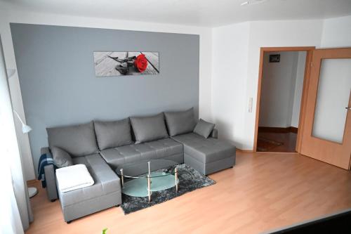 a living room with a gray couch and a table at Ferienwohnung Lindlar in Lindlar
