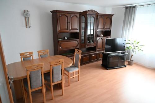 a dining room with a wooden table and a tv at Ferienwohnung Lindlar in Lindlar