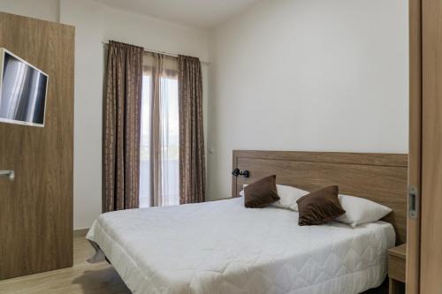 a bedroom with a large white bed and a window at Kalispera Residence in Scalea