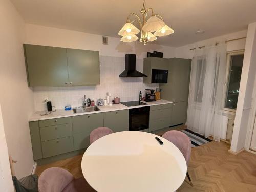 a kitchen with a white table and some chairs at Central Kauppakatu Apartment in Joensuu
