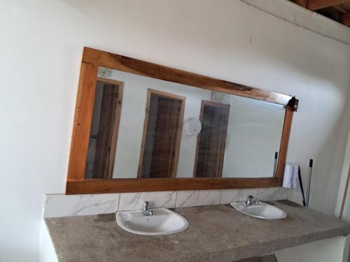 Ein Spiegel über zwei Waschbecken in einem Badezimmer in der Unterkunft HostalElCascolManabiPuertolopez in Puerto López