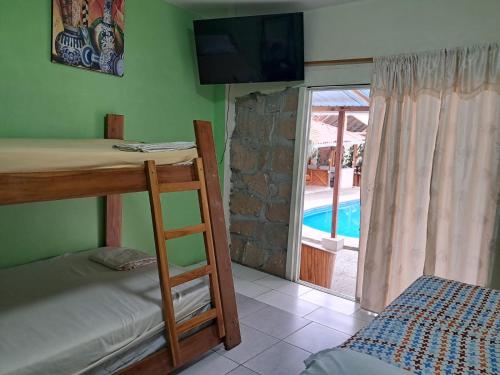 ein Schlafzimmer mit Etagenbett und Blick auf einen Pool in der Unterkunft HostalElCascolManabiPuertolopez in Puerto López