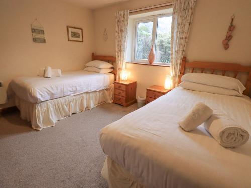 a bedroom with two beds and a window at Thrang View in Ambleside