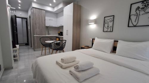 a bedroom with a white bed with towels on it at SKG Modernity Studio in Thessaloniki