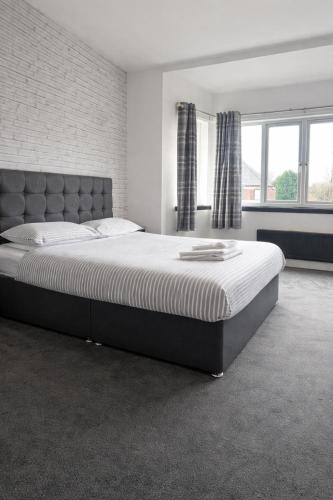 Beverley Hotel في والسال: غرفة نوم بسرير كبير في غرفة بها نوافذ