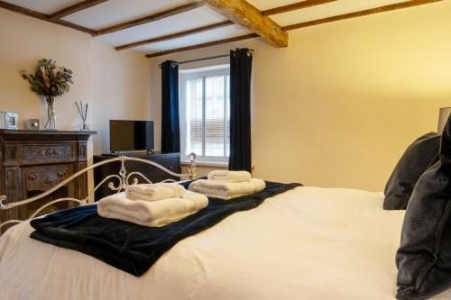 a bedroom with a bed with towels on it at Mill Workers Cottage in Cromford