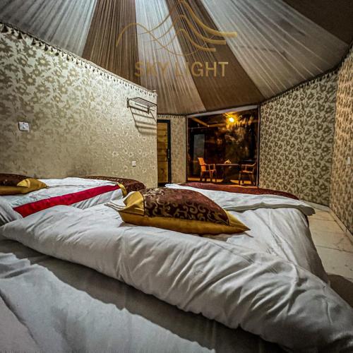a large bed with a pillow on top of it at Skylight Wadi Rum Camp in Disah