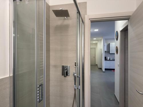 a glass shower door in a bathroom with a hallway at Suite Prisma - Modern & Spacious Apartment near Verona Fair in Verona