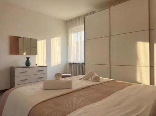 a bedroom with a large bed with towels on it at Suite Prisma - Modern & Spacious Apartment near Verona Fair in Verona