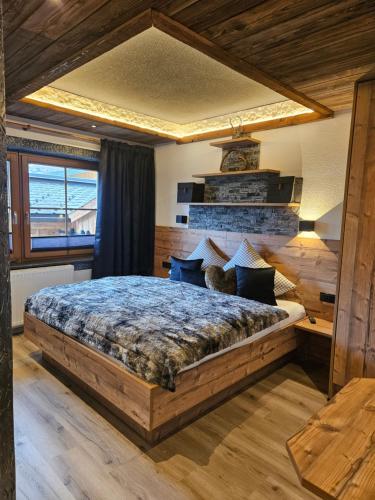 a bedroom with a large wooden bed in a room at Luxus Apartment Nina mit Zirbenhütte in Ramsau im Zillertal
