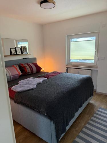 a bedroom with a large bed and a window at Pro Home FeWo Hiddenhausen in Hiddenhausen