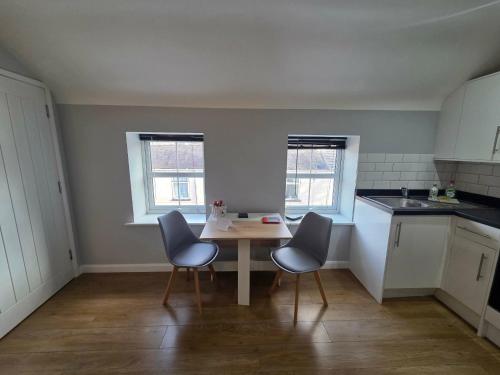 a small kitchen with a table and two chairs at 4a Smart Apartments in Newark-on-Trent