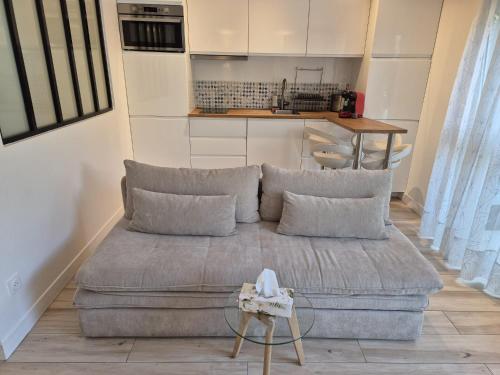 a living room with a couch and a kitchen at Maison chaleureuse jacuzzi PS2-1, climatisation et parking payants in Bagneux