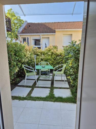 a patio with a table and chairs in a backyard at Maison chaleureuse jacuzzi PS2-1, climatisation et parking payants in Bagneux