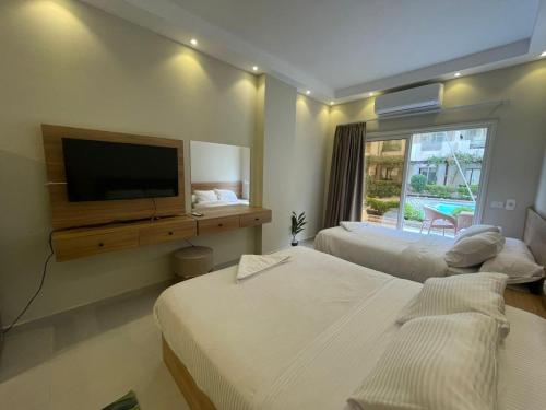 a bedroom with two beds and a flat screen tv at florenza Resort - Hurghada Egypt in Hurghada