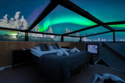 a room with two beds and a view of the northern lights at Aurora Paradise Levi Iglu in Levi