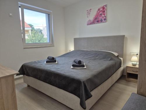 a bedroom with a bed with two hats on it at Natalija Adriatic 2 in Krk