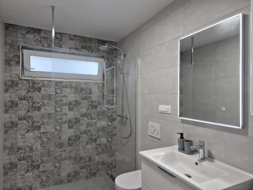 a bathroom with a sink and a toilet and a mirror at Natalija Adriatic 2 in Krk