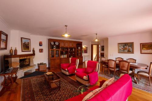 a living room with red furniture and a dining room at Varanda do Outeiro in Melgaço