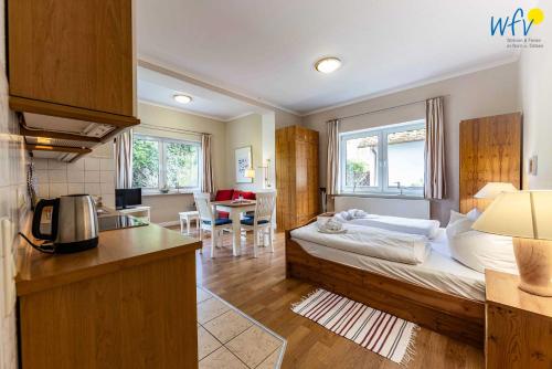 a bedroom with a bed and a kitchen with a table at Haus am Hövt - Ferienwohnung 1 in Göhren