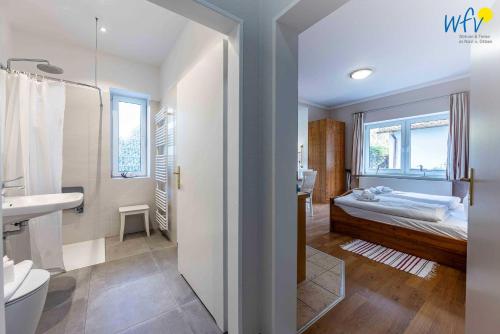 a bathroom with a bedroom with a bed and a sink at Haus am Hövt - Ferienwohnung 1 in Göhren