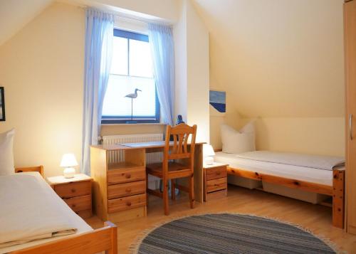 a bedroom with a desk and a bed and a window at Hagebutte in Am Schwarzen Busch