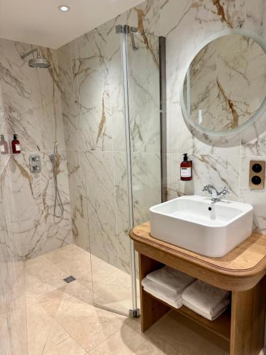 a bathroom with a sink and a shower at Logis Hôtel Maison Turenne in Martel