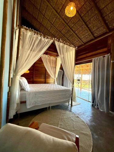 a bedroom with two beds with mosquito nets at Pousada Villa Velejo in Grossos