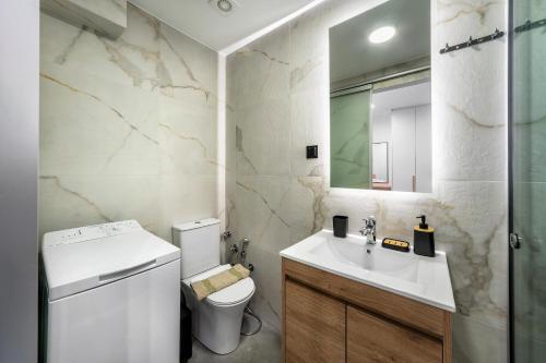 a bathroom with a sink and a toilet and a mirror at Eirini & Nicol Studios by Cretanhouses in Thérissos