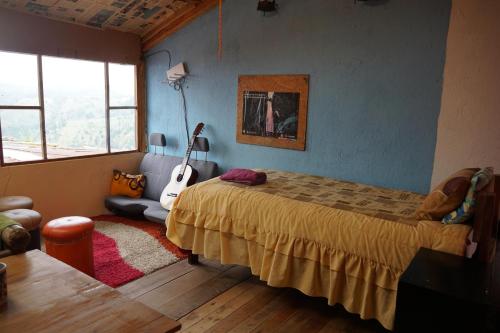 ein Schlafzimmer mit einem Bett und einer Gitarre darin in der Unterkunft Starlight Mountain Lodge SIGCHOS in Sigchos