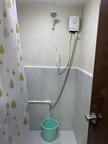 a shower with a blue bucket in a bathroom at ARC Hive Staycation in Suba