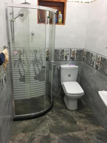 a bathroom with a shower and a toilet and a sink at Ranga's house in Minuwangoda