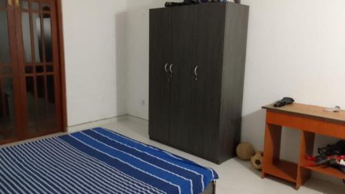 a bedroom with a black cabinet next to a bed at Ranga's house in Minuwangoda