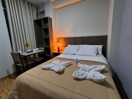 a bedroom with a bed with two white towels on it at Hotel Ayacucho in San Antonio