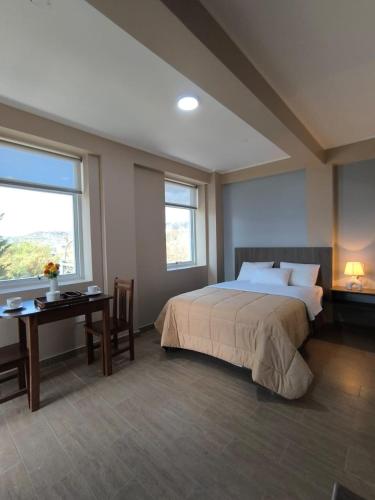 a bedroom with a large bed and a desk with a desk at Hotel Ayacucho in San Antonio