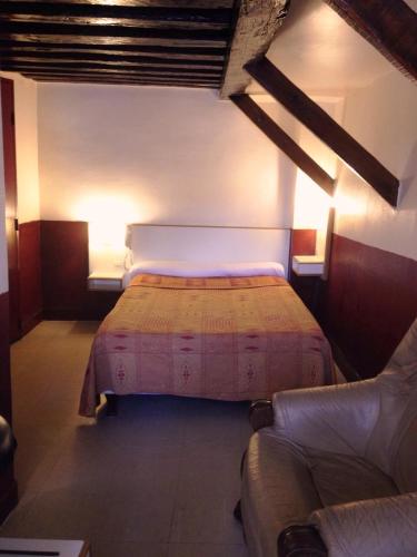 une chambre avec un lit et un canapé dans une pièce dans l'établissement Hôtel du Pont Neuf, à Paris