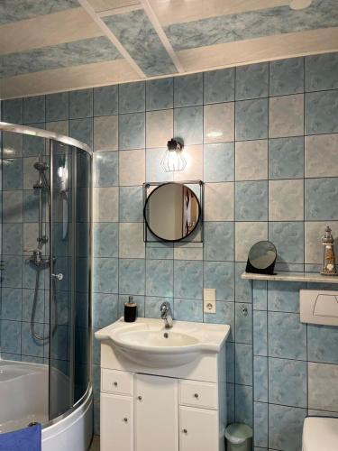 a bathroom with a sink and a shower and a mirror at Bella Patria in Rozwadza