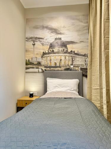 a bedroom with a bed and a painting of a building at Lichtdurchflutetes Design-Apartment U39-1 in Niederdorla