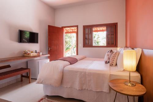 a bedroom with a bed with a lamp and a piano at Pousada Rávis - Café e Descanso in Sabará