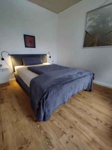 a bedroom with a bed with a blue blanket on it at Frisch saniertes Apartment am Falderapark in Neumünster