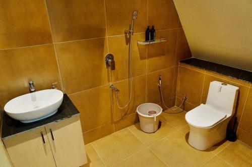 a bathroom with a sink and a toilet and a shower at SkyGrove in Kodaikānāl