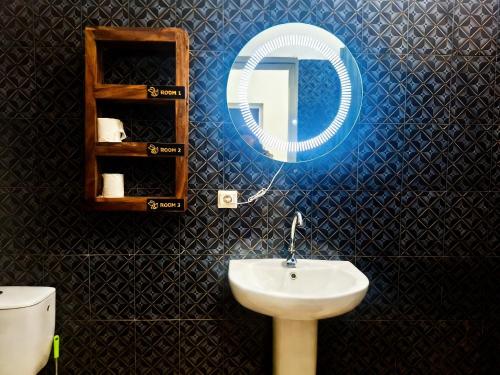 a bathroom with a sink and a mirror and a toilet at Bee Rooms Nosy be in Ambatoloaka