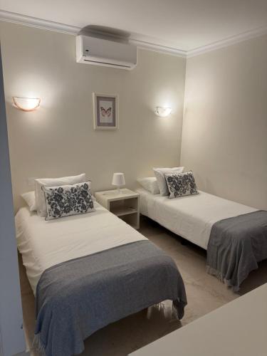 a room with two beds and a night stand at Mogán suite in Puerto de Mogán