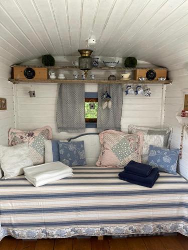 a couch in the back of a trailer with pillows at Romantischer Zirkuswagen in Edemissen
